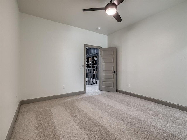 spare room with light carpet and ceiling fan