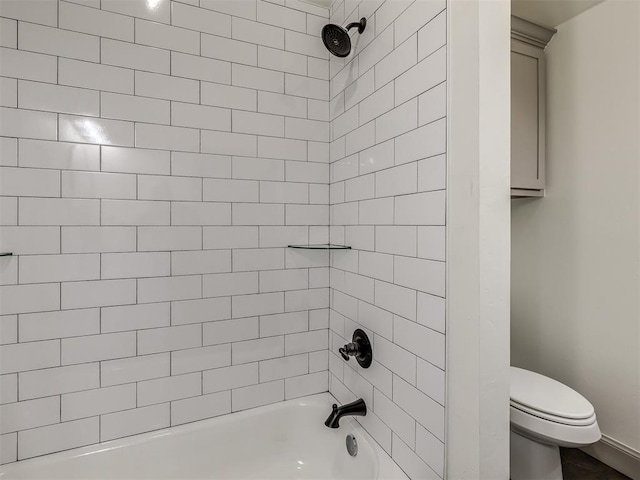 bathroom with toilet and tiled shower / bath