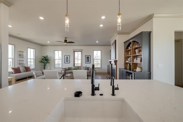 kitchen featuring pendant lighting, a wealth of natural light, and crown molding