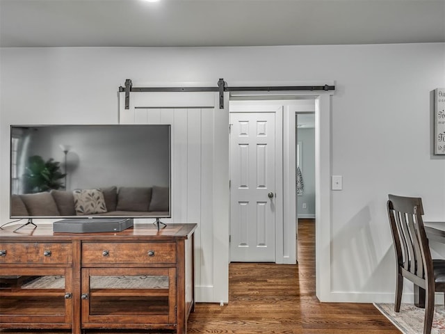 living room featuring a barn door and dark hardwood / wood-style floors