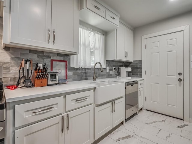 kitchen with stainless steel dishwasher, backsplash, white cabinetry, and sink