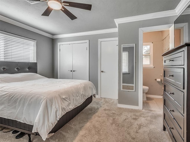 carpeted bedroom featuring ceiling fan, ensuite bathroom, and ornamental molding