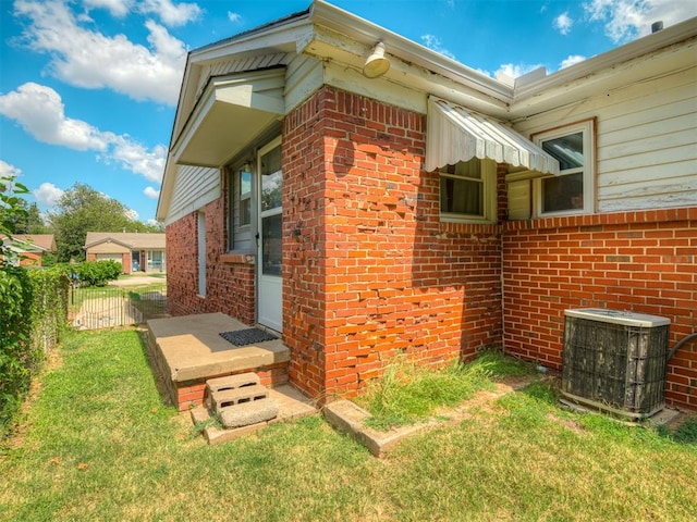 view of side of home with central air condition unit and a lawn