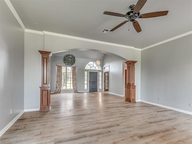 unfurnished living room with ceiling fan with notable chandelier, ornate columns, crown molding, and light hardwood / wood-style flooring