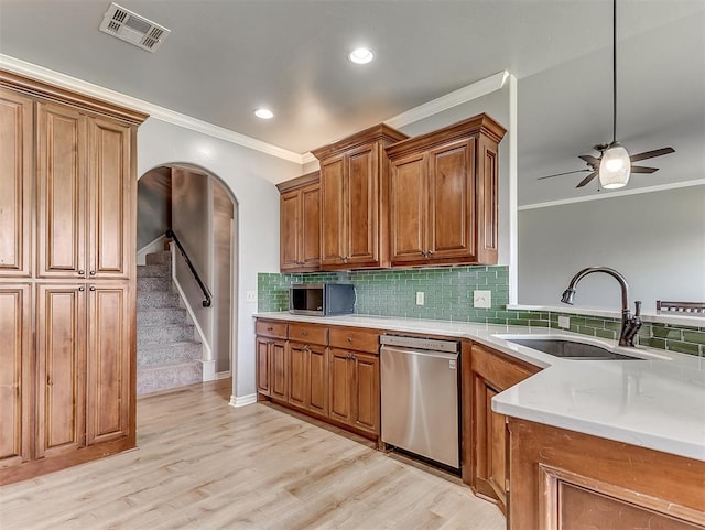 kitchen with ceiling fan, sink, stainless steel appliances, light hardwood / wood-style floors, and decorative backsplash