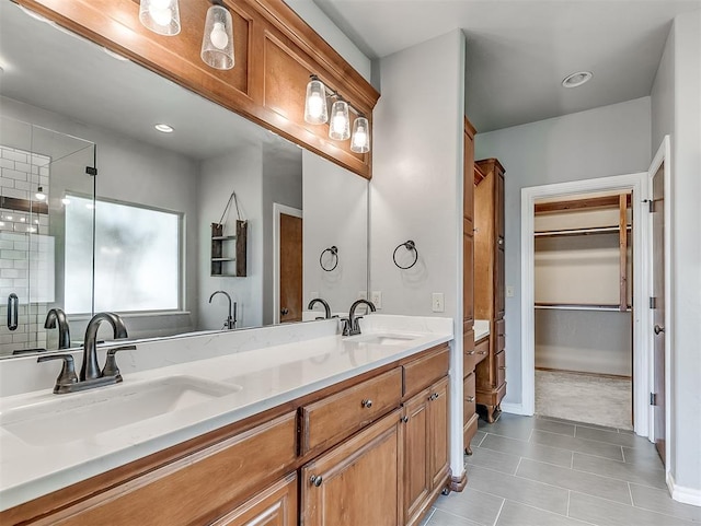 bathroom with tile patterned floors, a shower with door, and vanity