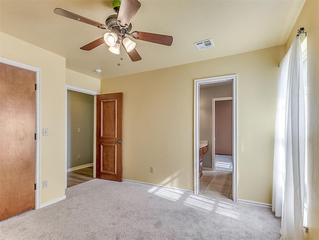 unfurnished bedroom featuring light colored carpet and ceiling fan