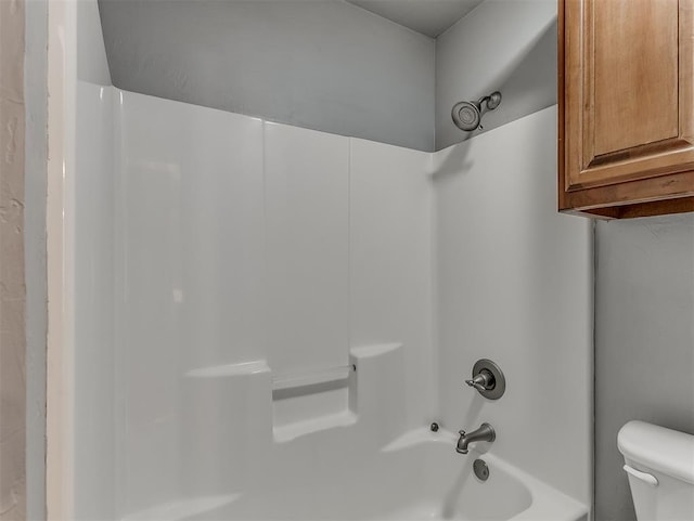 bathroom featuring bathtub / shower combination and toilet