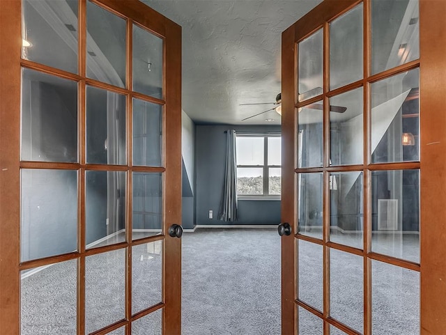 carpeted spare room with ceiling fan, french doors, and a textured ceiling