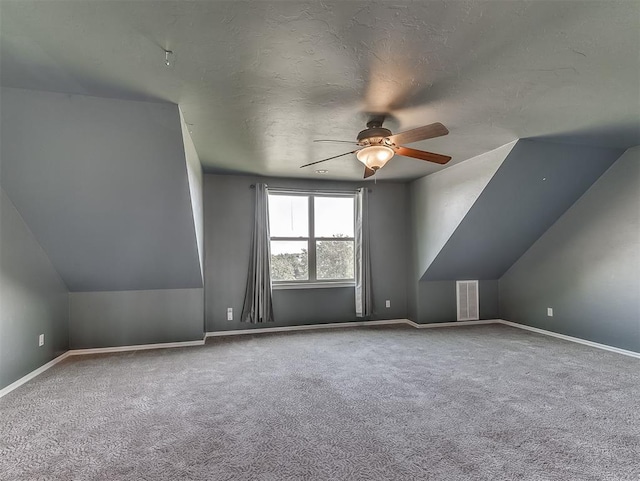 additional living space with carpet flooring, ceiling fan, lofted ceiling, and a textured ceiling