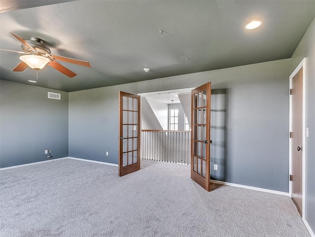 empty room featuring ceiling fan, french doors, and carpet floors