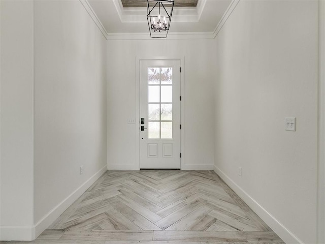 doorway with light parquet flooring, ornamental molding, an inviting chandelier, and a tray ceiling