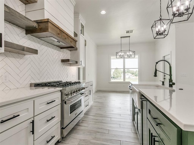 kitchen with green cabinetry, white cabinetry, pendant lighting, and high end stove