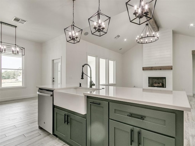 kitchen featuring sink, dishwasher, a kitchen island with sink, green cabinetry, and decorative light fixtures