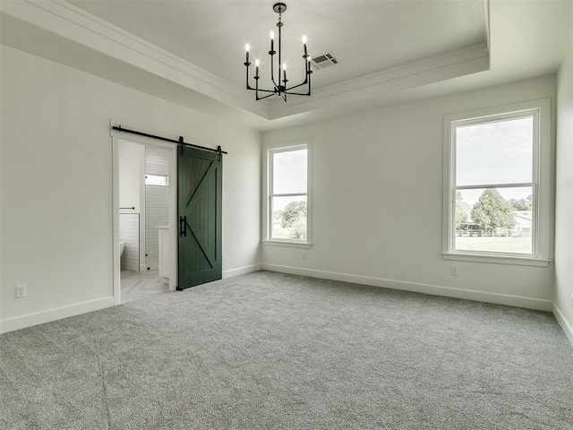 interior space featuring light carpet, crown molding, a raised ceiling, and a barn door