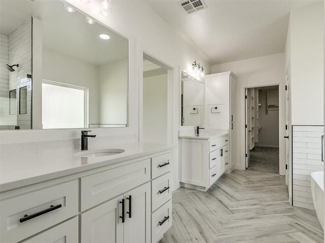 bathroom with vanity, parquet flooring, and walk in shower