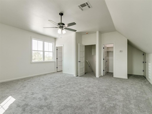 unfurnished bedroom featuring ceiling fan, light colored carpet, and vaulted ceiling