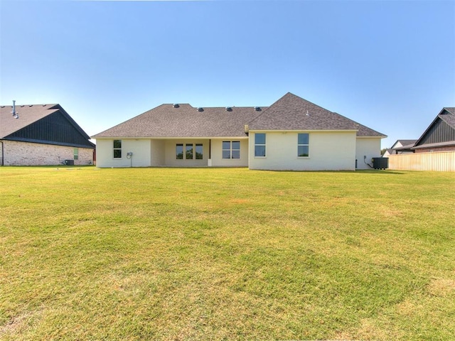 back of property with a yard and central air condition unit