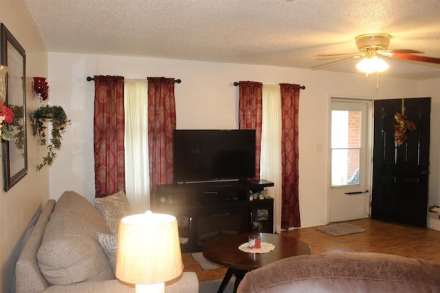 living room with ceiling fan and a textured ceiling