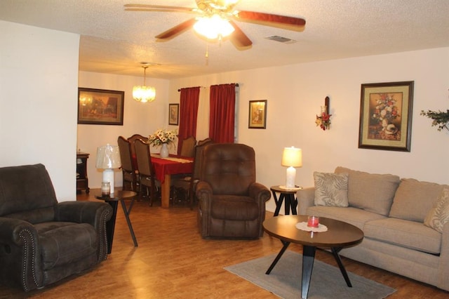 living room with ceiling fan, hardwood / wood-style floors, and a textured ceiling