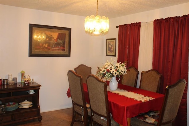 dining space featuring a notable chandelier and a textured ceiling