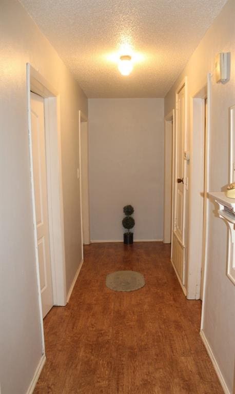 corridor featuring wood-type flooring and a textured ceiling