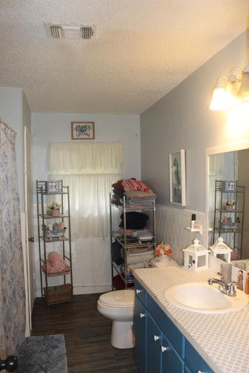 bathroom with vanity, hardwood / wood-style floors, a textured ceiling, and toilet