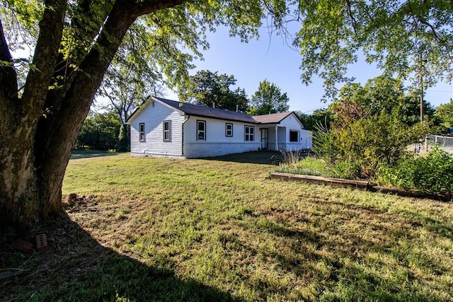 rear view of property featuring a yard