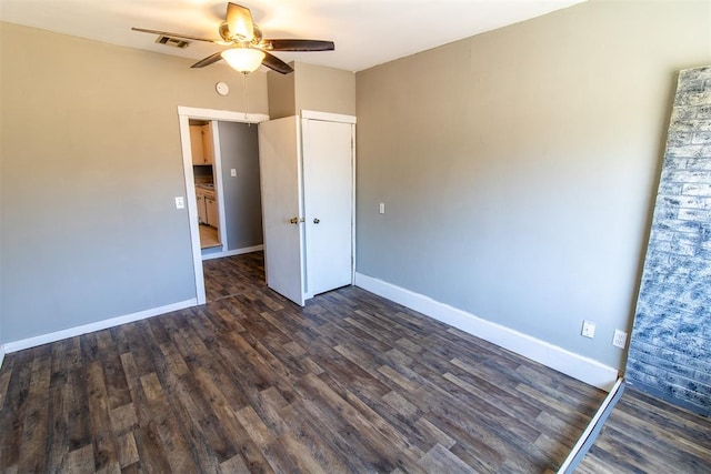 unfurnished bedroom featuring ceiling fan and dark hardwood / wood-style flooring