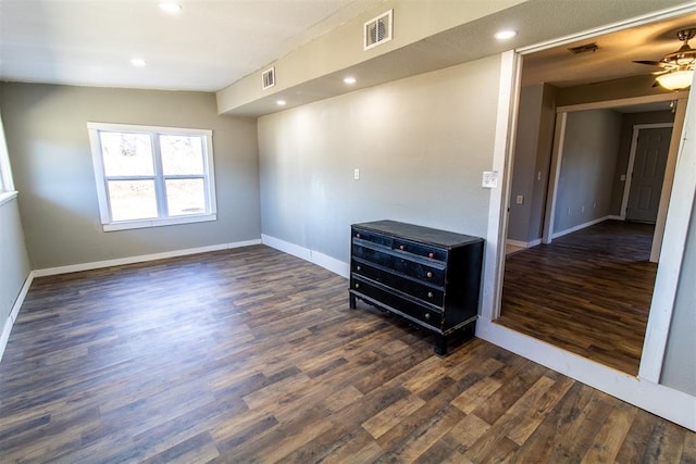 empty room with ceiling fan and dark wood-type flooring