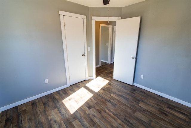 unfurnished bedroom with ceiling fan and dark hardwood / wood-style floors