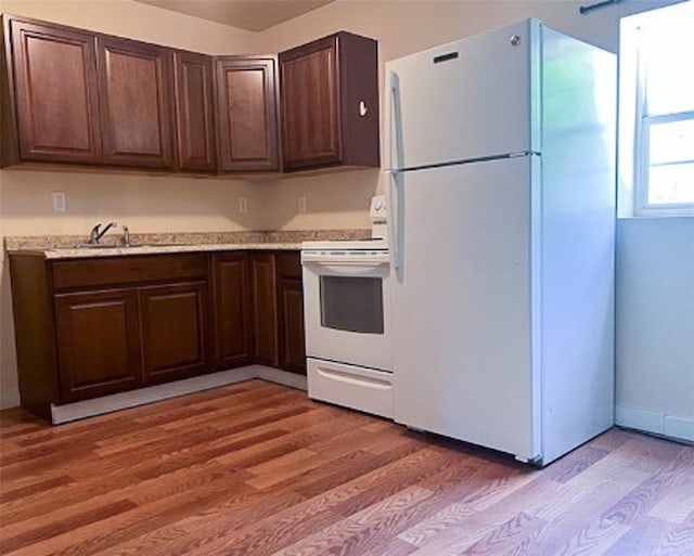 kitchen featuring hardwood / wood-style floors, white appliances, dark brown cabinets, and sink