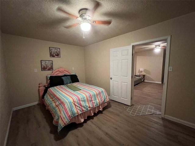 bedroom with ceiling fan, dark hardwood / wood-style flooring, and a textured ceiling