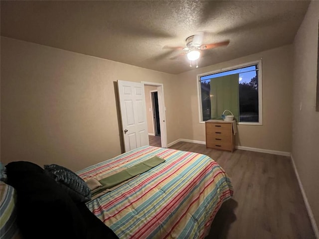 bedroom with wood-type flooring, a textured ceiling, and ceiling fan