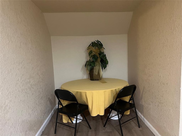 dining room with hardwood / wood-style flooring and lofted ceiling