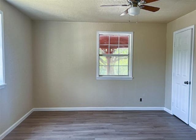 spare room featuring ceiling fan and dark wood-type flooring