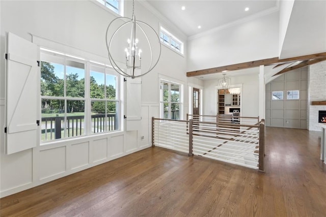 interior space with dark hardwood / wood-style flooring, a stone fireplace, and plenty of natural light