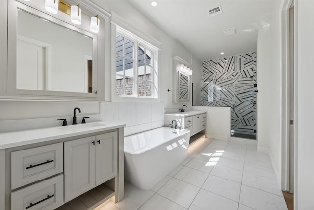 bathroom featuring a bath, vanity, and tile walls