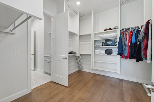 walk in closet with light hardwood / wood-style floors