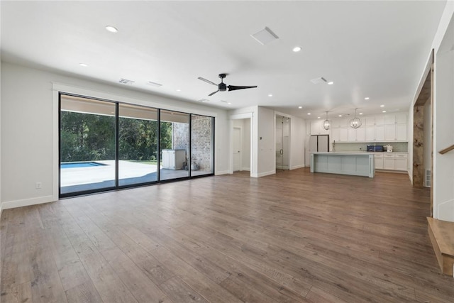 unfurnished living room featuring ceiling fan and wood-type flooring