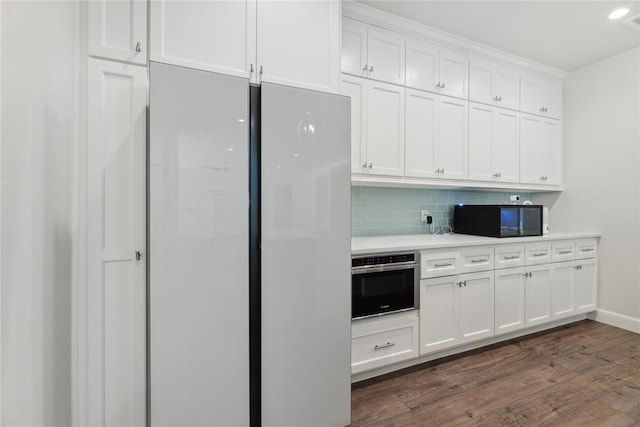 kitchen with white cabinets, white fridge, stainless steel oven, and dark hardwood / wood-style flooring