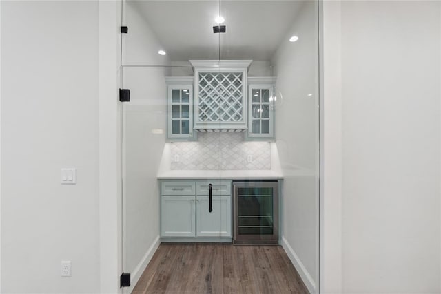 bar featuring dark hardwood / wood-style flooring, white cabinetry, wine cooler, and backsplash