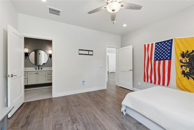 unfurnished bedroom featuring ceiling fan, sink, ensuite bathroom, and hardwood / wood-style flooring