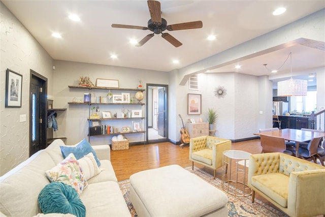 living room with ceiling fan and light hardwood / wood-style flooring