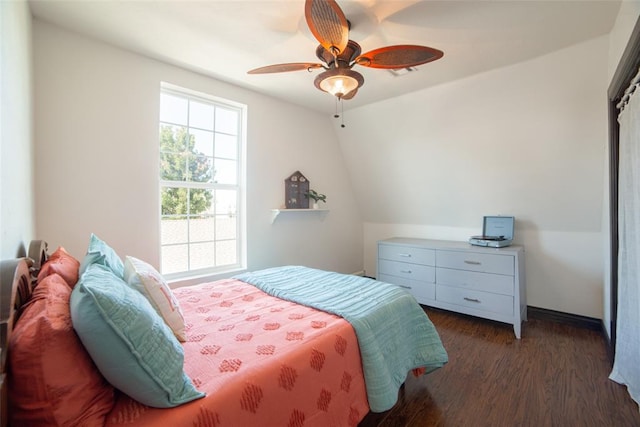 bedroom with ceiling fan, dark wood-type flooring, and lofted ceiling