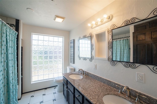 bathroom featuring toilet, tile patterned flooring, and vanity