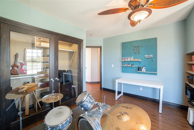 living room featuring ceiling fan and dark hardwood / wood-style flooring