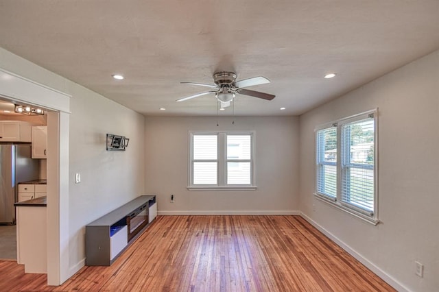 unfurnished living room with ceiling fan and light wood-type flooring