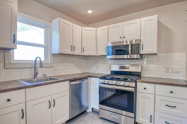 kitchen featuring white cabinets, decorative backsplash, sink, and stainless steel appliances