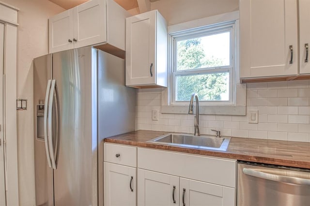 kitchen featuring white cabinets, stainless steel appliances, a wealth of natural light, and sink